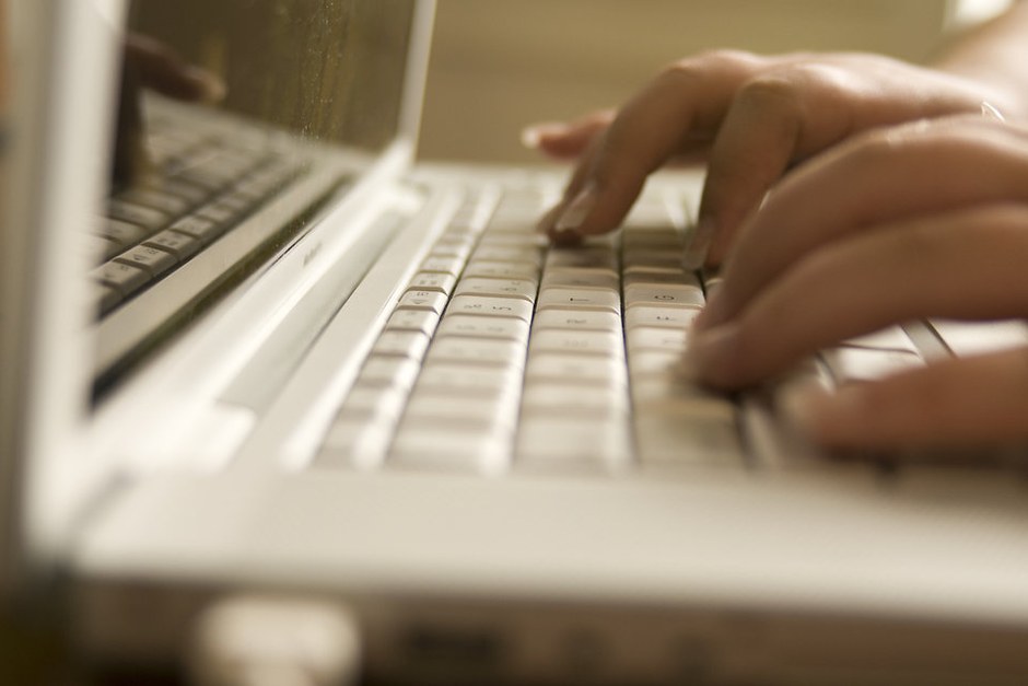 Hands typing on a laptop